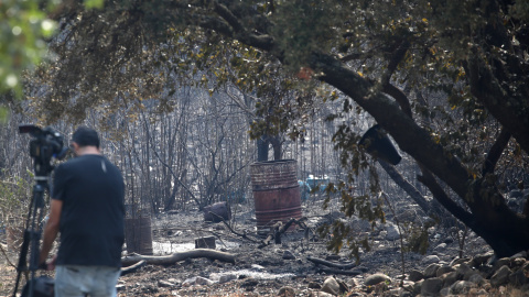 Reportero toma imágenes tras el paso del incendio que ha afectado al espacio natural de Las Médulas (León)