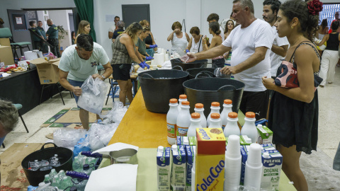 Varios voluntarios disponen alimentos para los desalojados del incendio de Tarifa (Cádiz), este martes en una instalación de la localidad vecina de Zahara de los Atunes (Cádiz)