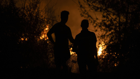 Dos personas observan la evolución del incendio forestal en A Rúa (Ourense), en la madrugada del 16 de agosto de 2025. Dos personas observan la evolución del incendio forestal en A Rúa (Ourense), a 16 de agosto de 2025.