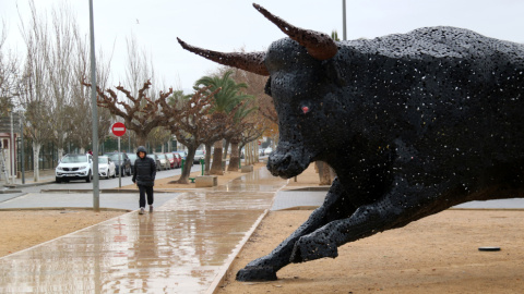 68a43fbdde1b1 Una persona pasa junto a la figura del toro que hace un homenaje a la afición taurina de Amposta.