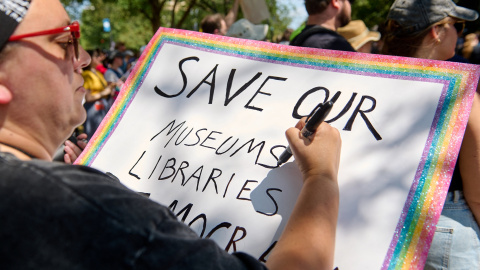 Un mujer escribe una pancarta abogando por la preservación de museos y bibliotecas durante una marcha por Washington D.C. en protesta por el despliegue de la Guardia Nacional decretada por Donald Trump. Un mujer escribe una pancarta abogando por la preservación de museos y bibliotecas durante una marcha por Washington D.C. en protesta por el despliegue de la Guardia Nacional decretada por Donald Trump.