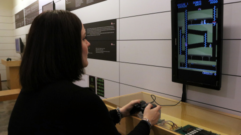 Una noia jugant amb un dels videojocs d'una exposició del Museu del Joguet