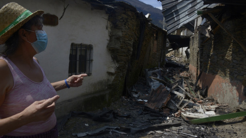 Una mujer observa varias viviendas quemadas el pasado martes en Cernego, en el municipio ourensano de San Martín de Valdeorras. Una mujer observa varias viviendas quemadas el pasado martes en Cernego, en el municipio ourensano de San Martín de Valdeorras.