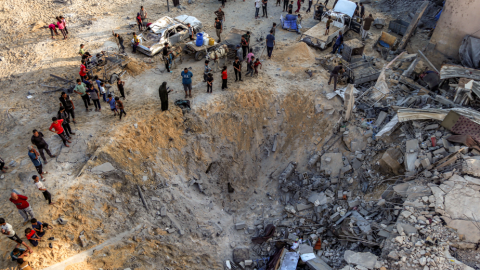 Personas alrededor de un edificio destruido por Istael en Jan Yunis.