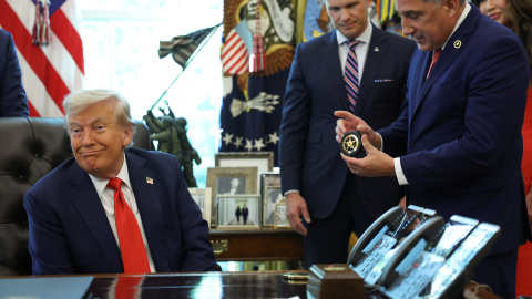 El presidente de EEUU, Donald Trump, con el director del Servicio de Marshals, Gadyaces Serralta, que le entrega una placa de agente durante la firma de órdenes ejecutivas en el Despacho Oval de la Casa Blanca, en Washington DC.