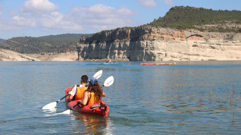 Una parella navega pel pantà de Canelles amb kayak Una parella navega pel pantà de Canelles amb kayak