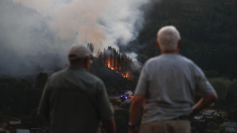 Dos vecinos frente a un incendio forestal en Quiroga, Lugo. Dos vecinos frente al incendio forestal que afectó a Quiroga, en Lugo.