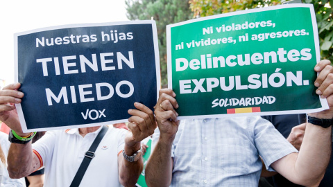 Dos hombres con carteles durante la protesta organizada por Vox contra el centro de Primera Acogida de Hortaleza, este 2 de septiembre de 2025 en Madrid.