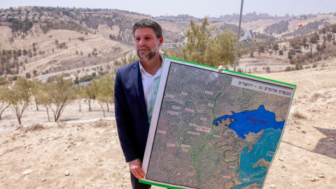 El ministro de Finanzas israelí de extrema derecha, Bezalel Smotrich, sostiene un mapa de una zona cercana al asentamiento de Maale Adumim, en la Cisjordania ocupada / 14.08.25
