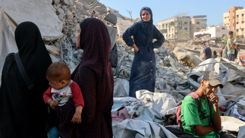 Un grupo de palestinos revisan los escombros de un edificio en Gaza.