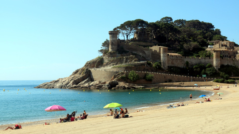 Alguns banyistes a la platja de Tossa de Mar amb la Vila Vella al fons Alguns banyistes a la platja de Tossa de Mar amb la Vila Vella al fons
