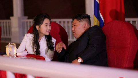 El líder norcoreano Kim Jong-un y su hija Kim Ju Ae conversan mientras asisten a la ceremonia de botadura de un buque de guerra.