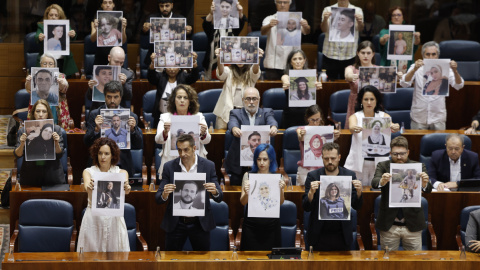 Diputados regionales de Más Madrid muestran fotos de palestinos asesinados en Gaza.