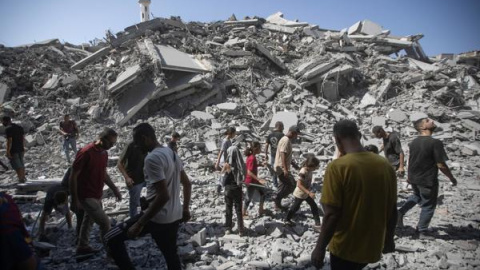 Palestinos inspeccionan los escombros del edificio residencial Al-Ghafari tras ser alcanzado por un ataque aéreo israelí en la ciudad de Gaza.