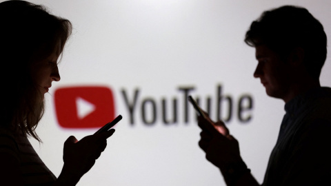 Unos jóvenes mirando sus smartphones junto al logo de Youtube.