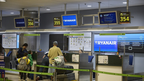 Varias personas en un puesto de facturación de Ryanair.