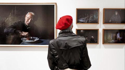 Una persona observa varias fotografías de la exposición "Habitar o baleiro".