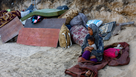 Una mujer palestina desplazada con un niño, que huye del norte de Gaza debido a una operación militar israelí, descansa después de evacuar hacia el sur siguiendo las órdenes de las fuerzas israelíes de abandonar la ciudad de Gaza, en el centro de la Franj Una mujer palestina desplazada con un niño, que huye del norte de Gaza debido a una operación militar israelí, descansa después de evacuar hacia el sur siguiendo las órdenes de las fuerzas israelíes de abandonar la ciudad de Gaza, en el centro de la Franja de Gaza, el 23 de septiembre de 2025. REUTERS/Mahmoud Issa