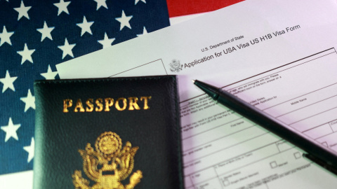 El impreso del visado H-1B junto una bandera y un pasaporte de EEUU. El impreso del visado H-1B junto una bandera y un pasaporte de EEUU.