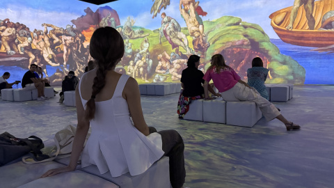 Diverses persones observant les projeccions d'una de les sales de l'experiència immersiva 'Leonardo versus Michelangelo' a l'IDEAL de Barcelona