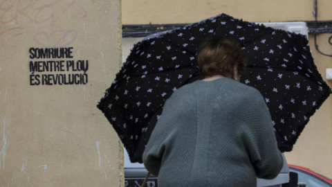 Una mujer se protege de la lluvia con un paraguas en València.
