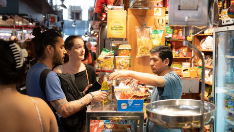 Varias personas compran en el mercado de la Boquería, en Barcelona.