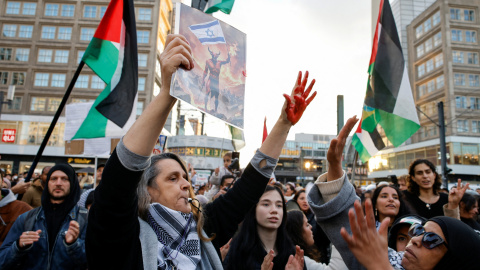 Una persona muestra las manos manchadas de rojo en la manifestación de Berlín.