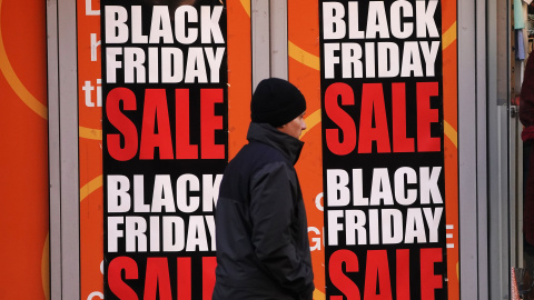 EuropaPress_4835239_25_november_2022_ireland_dublin_aman_walks_by_signs_for_black_friday_sales Foto de archivo de un hombre junto a los carteles de ofertas del Black Friday.