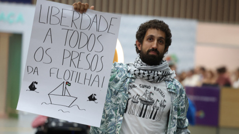 El activista Nico Calabrese, detenido por Israel mientras participaba en la Flotilla Global Sumud que buscaba entregar ayuda a Gaza, muestra un cartel que dice "Libertad a todos los prisioneros de la Flotilla" a su llegada al Aeropuerto Internacional Galeao en Río de Janeiro, Brasil, el 6 de octubre de 2025. REUTERS/Pilar Olivares
