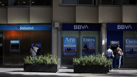 Una oficina del Banco Sabadell junto a otra del BBVA en una calle de Barcelona.