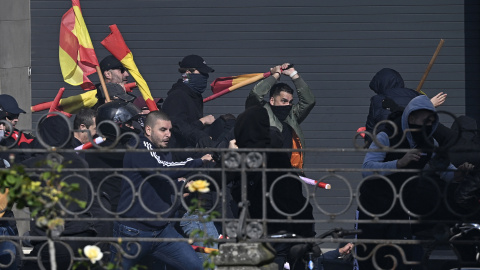 Falange far-right group supporters (L) clash with anti-fascist counter-protesters (R) during a rally called by Falange Espanola de las JONS for the unity of Spain and marking Spain's National Day in Vitoria on October 12, 2025. The Basque regional police Ertzaintza detained 17 people following the incidents. (Photo by ANDER GILLENEA / AFP)