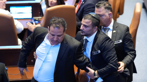 Un oficial de seguridad expulsa a un miembro del Parlamento.