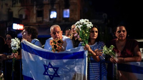 AFP__20251013__78N97L2__v1__HighRes__IsraelPalestinianConflict Israelíes con flores y banderas a la llegada de vehículos con los cuerpos de cuatro rehenes entregados por Hamás.