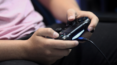 Un joven con un mando de consola.