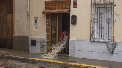 Un hombre achica agua en Llombai, València.