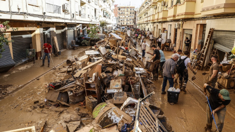 Decenas de personas limpian los estragos ocasionados por la DANA en las calles de València.