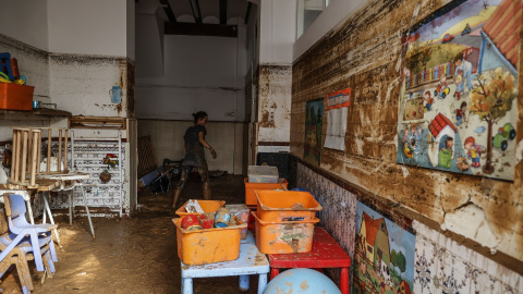 Una mujer limpia los estragos ocasionados por la DANA.