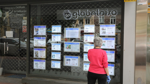 Una mujer echa un vistazo a las ofertas de una agencia inmobiliaria Una mujer echa un vistazo a las ofertas de una agencia inmobiliaria, en una imagen de archivo.