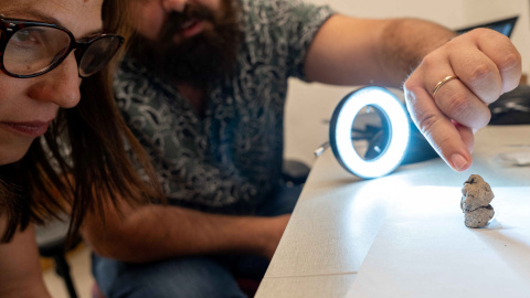 Los investigadores examinan la pequeña estatuilla de arcilla de 12.000 años de antigüedad descubierta en un yacimiento arqueológico en el norte de Israel. Los investigadores examinan la pequeña estatuilla de arcilla de 12.000 años de antigüedad descubierta en un yacimiento arqueológico en el norte de Israel.