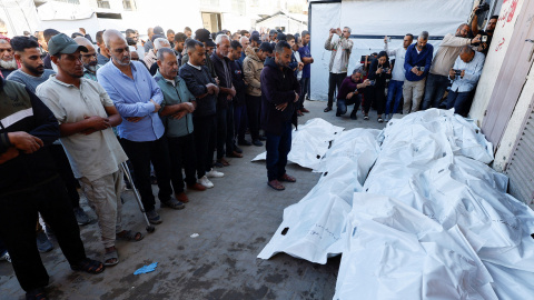 Personas asisten al funeral de los palestinos que  murieron en los ataques israelíes de este sábado, en el Hospital de los Mártires de Al-Aqsa, en el centro de la Franja de Gaza.
