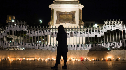 Una mujer pasa junto a velas encendidas y pancartas en la Plaza de la Merced de Málaga, con motivo del Día Internacional para la Eliminación de la Violencia contra las Mujeres en 2021. Una mujer pasa junto a velas encendidas y pancartas en la Plaza de la Merced de Málaga, con motivo del Día Internacional para la Eliminación de la Violencia contra las Mujeres en 2021.