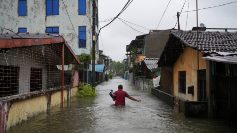 Un hombre camina por una calle inundada en Sri Lanka. Un hombre camina por una calle inundada en Sri Lanka.