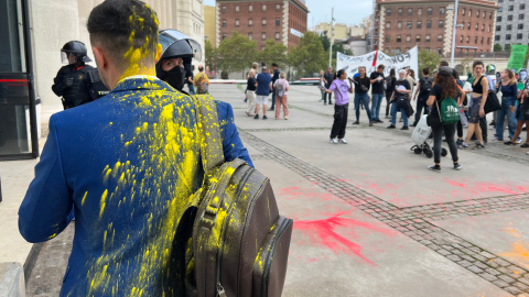 Imatge d'arxiu d'un congressista tancat de pintura quan entrava a The District, amb manifestants al fons