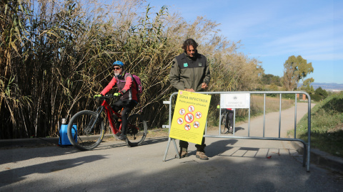 Un efectiu dels Agents Rurals col·locant un cartell informatiu sobre les restriccions