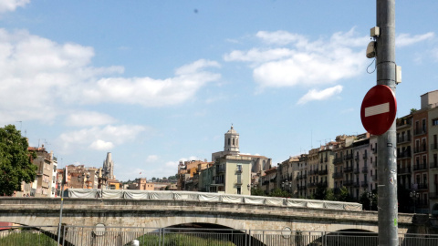 El sensor per comptar visitants al fanal i, al fons, la postal de les cases de l'Onyar de Girona