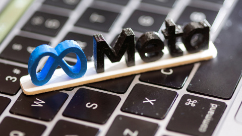 Una ilustración muestra el logo de Meta sobre el teclado de un portátil.