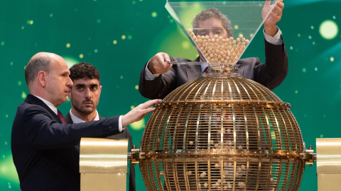 Varios hombres preparan el bombo para el Sorteo Extraordinario de la Lotería de Navidad.