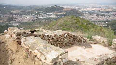 En primer terme el jaciment del Puig Castellar a Santa Coloma de Gramenet, amb Barcelona i el Vallès al fons