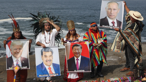 Un grupo de chamanes y curanderos sostienen imágenes de varios lideres mundiales durante un ritual de fin de año frente al océano Pacífico, en Lima (Perú). Un grupo de chamanes y curanderos sostienen imágenes de varios lideres mundiales durante un ritual de fin de año frente al océano Pacífico, en Lima (Perú).