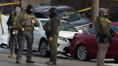 Miembros del ICE frente al coche en el que han tiroteado a una mujer.